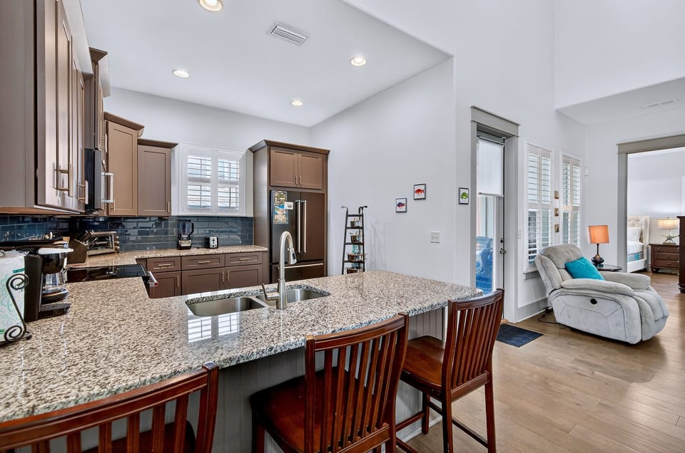 1st Floor - Fully equipped chef’s kitchen with modern appliances, spacious countertops—perfect for cooking meals during your Miramar Beach vacation in Destin. Open layout flows into the dining and living areas for easy entertaining and group gatherings.