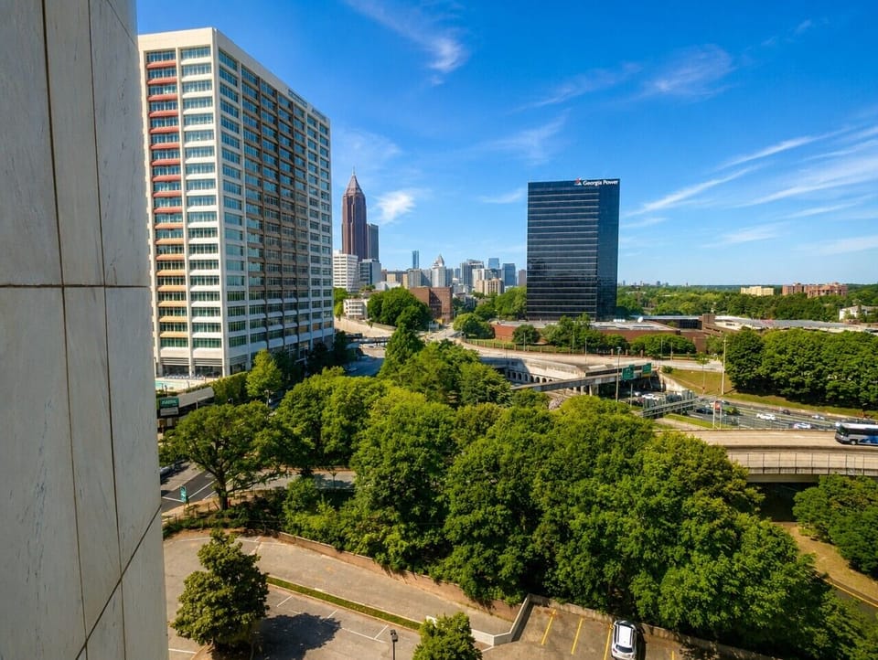 Rest easy with an Atlanta view. 🏙️ A comfortable bedroom, plenty of natural light, and city scenery create the perfect place to recharge between adventures.