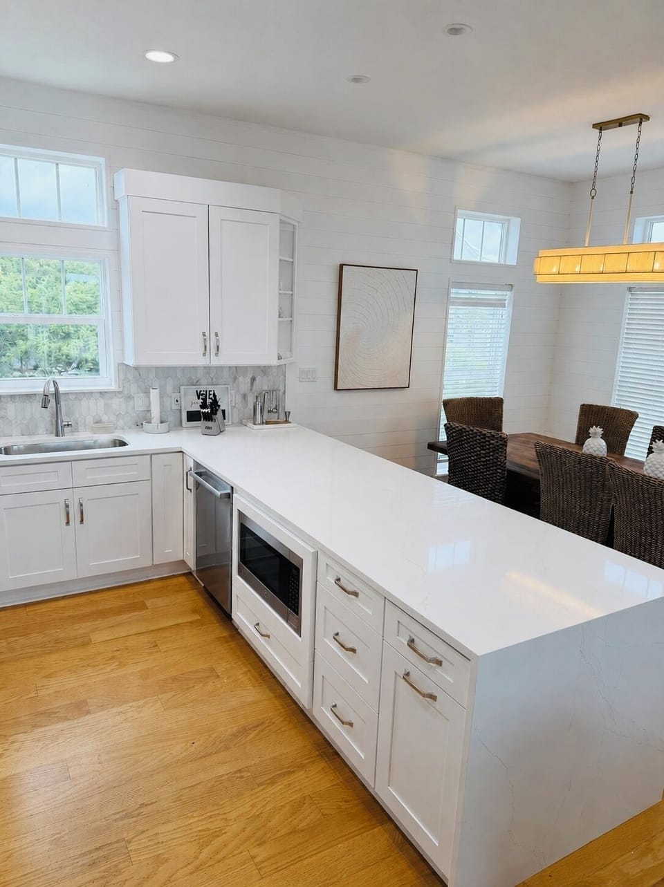 Bright coastal-style kitchen with large island and sunlit dining area