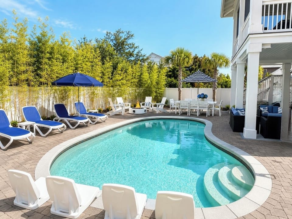 Private resort-style pool with loungers, shaded dining, and sunny patio