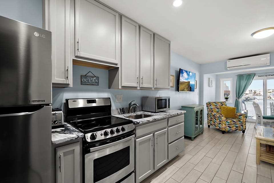 Modern galley kitchen with stainless steel appliances and plenty of counter space, open to the living room so the cook stays part of the fun.