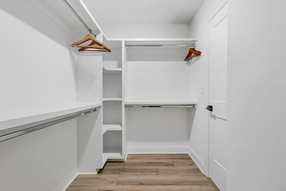 Generous walk in closet attached to ensuite bathroom with built in shelving and ample hanging space for dresses, suits, and elevated evening looks. And yes, of course there is a handheld steamer is here too!