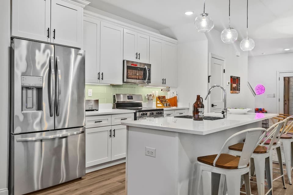 A fully stocked, bright and open kitchen, a spacious island with 4 bar stools, and tons of counter space. 