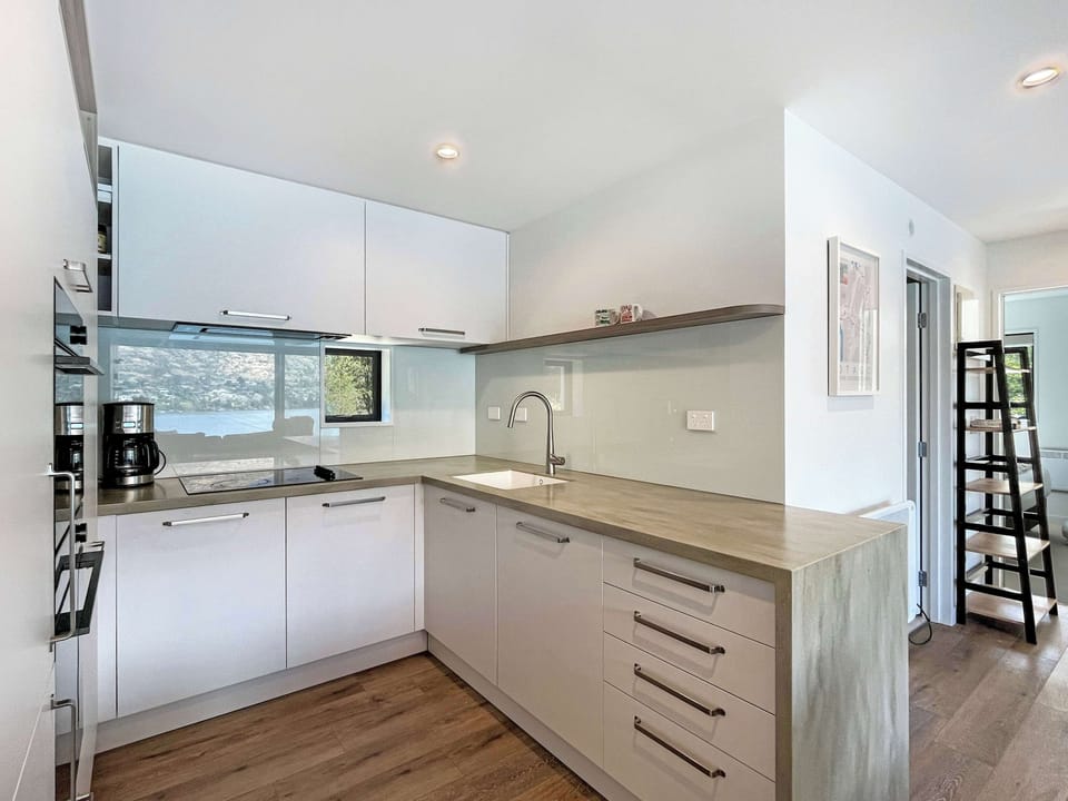 Modern kitchen with sleek cabinetry and lake glimpses in the reflections
