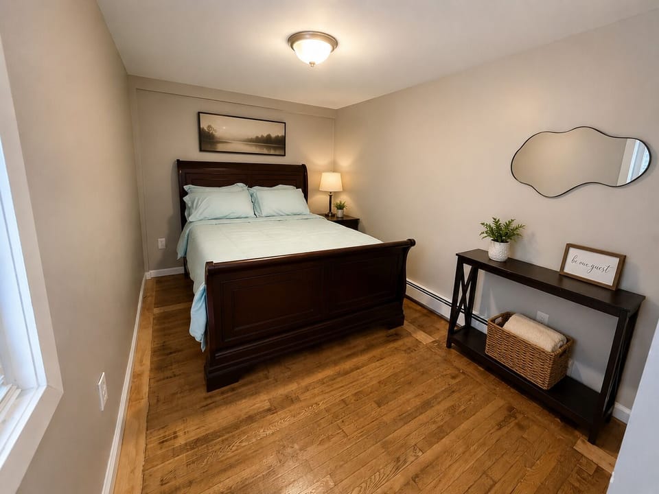Comfortable queen bedroom with fresh linens, mirror and storage space