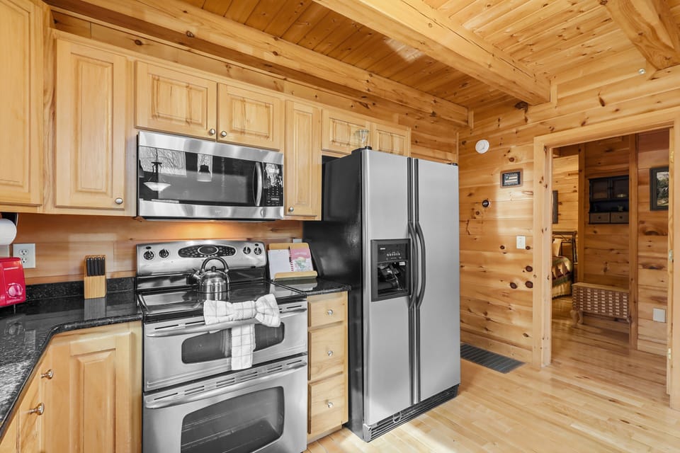 Kitchen with stainless steel stove, microwave, and French door fridge
