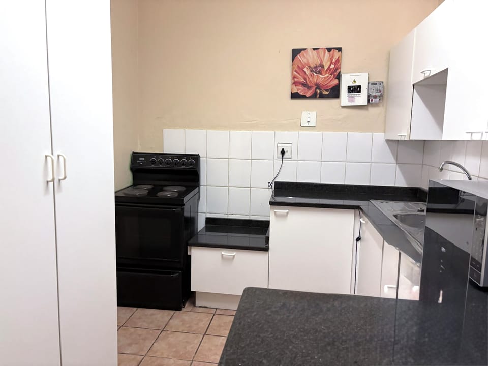 Modern Kitchenette with a stove and storage cupboards.