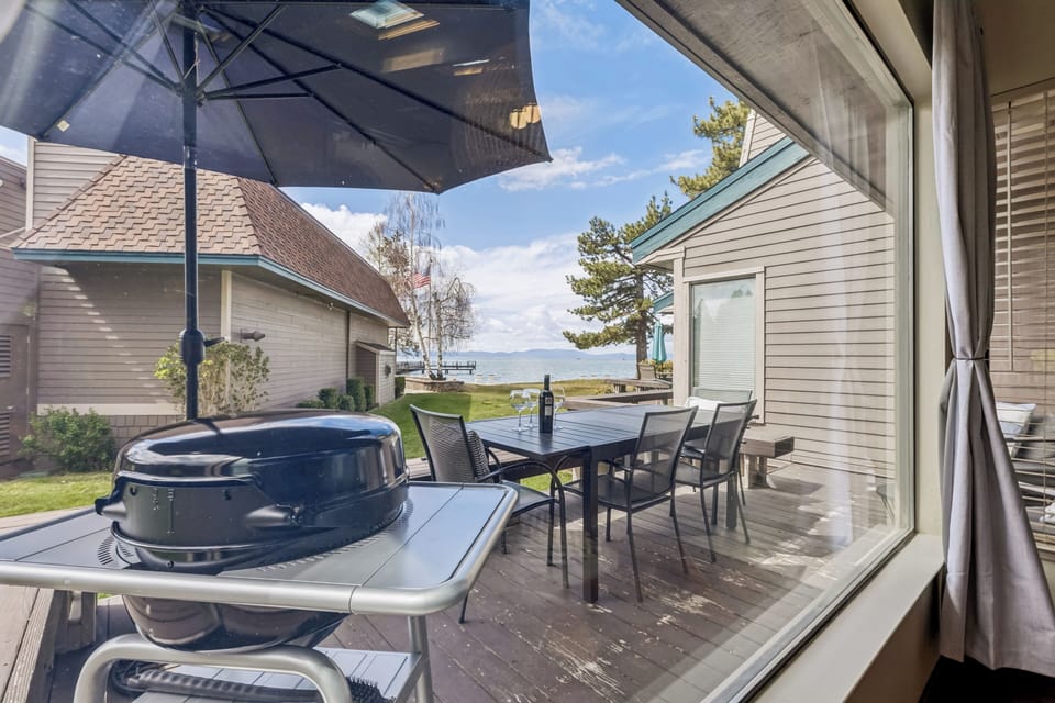 Outdoor deck with dining, grill, umbrella, and mountain views—perfect for al fresco meals and relaxation under open skies.