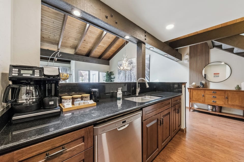 Your kitchen awaits with gleaming granite countertops, modern appliances, and warm wood cabinetry under vaulted ceilings—ready for morning coffee or family meals in this thoughtfully designed space.