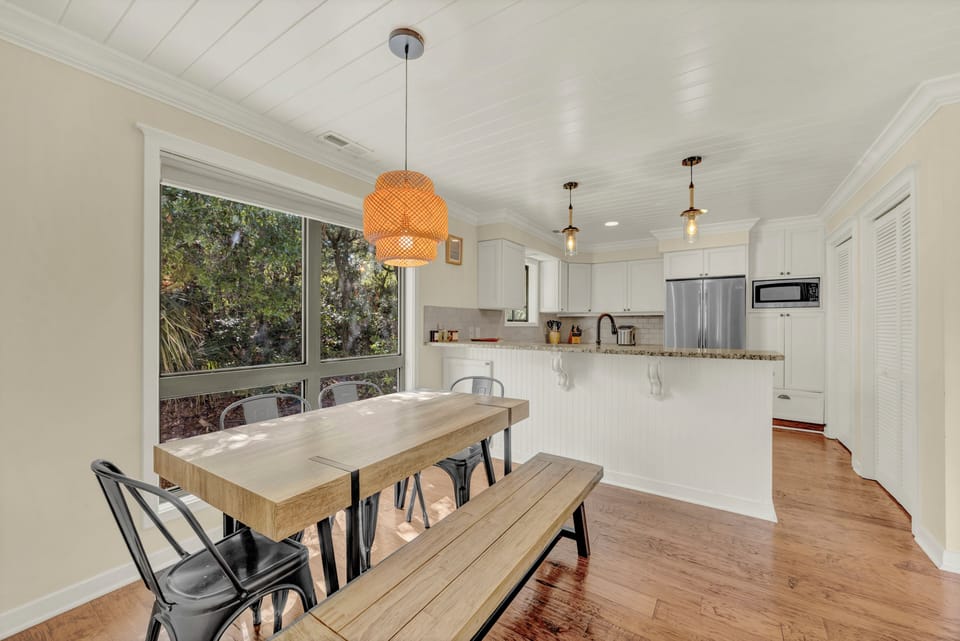 Gather around the farmhouse dining table where natural light pours through oversized windows, revealing garden views. The open kitchen invites you to cook and connect with loved ones.