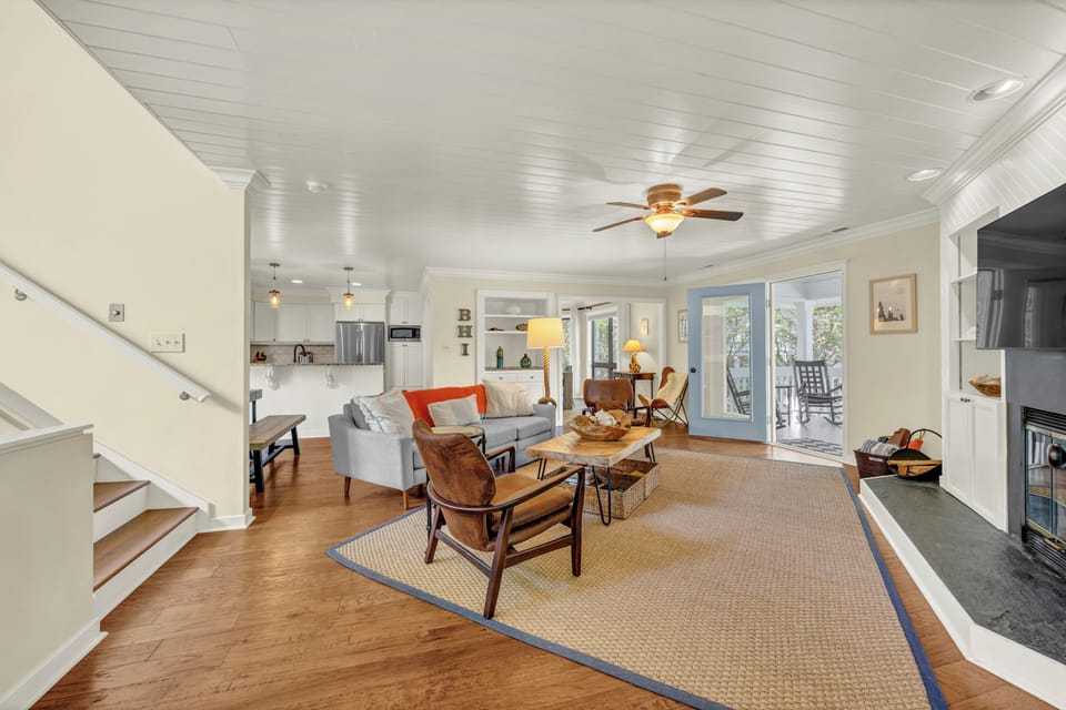 Relax in this light-filled living space with plush seating, warm hardwood floors, and French doors opening to your private deck. Enjoy cozy evenings under vaulted ceilings with a ceiling fan overhead.