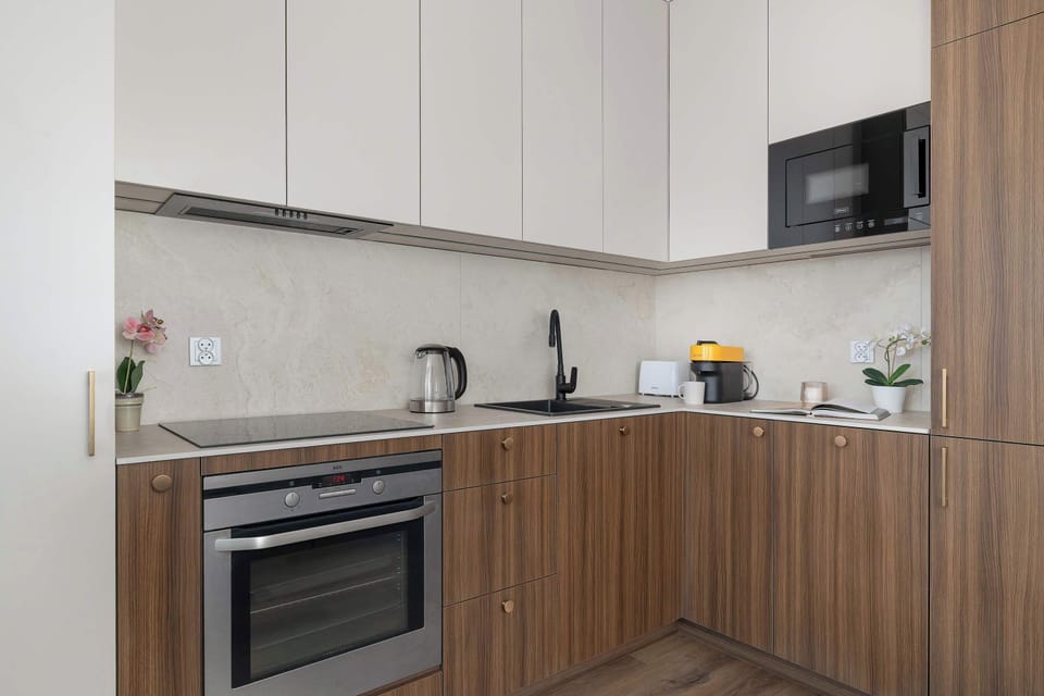 Another angle of the kitchen highlights a built-in oven, sink, and wooden countertops. The design is simple, clean, and functional.