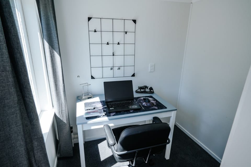 Dedicated home office with desk, chair, and natural lighting, ideal for remote work or study during your stay.