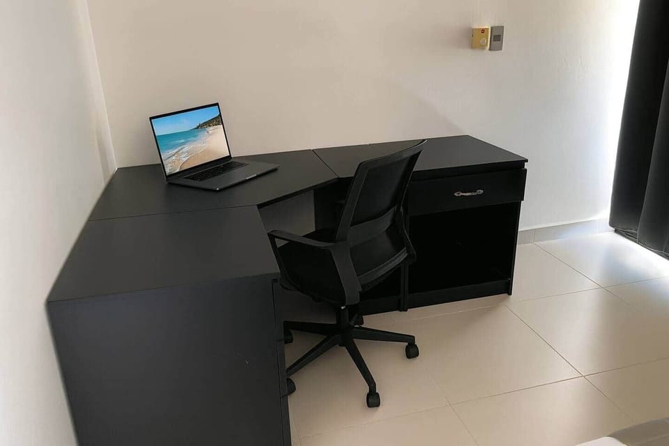 Designed with comfort and productivity in mind. The room features a sleek L-shaped desk and ergonomic chair, perfect for working remotely or studying. Natural light flows in through blackout curtains that can be drawn for privacy and rest.