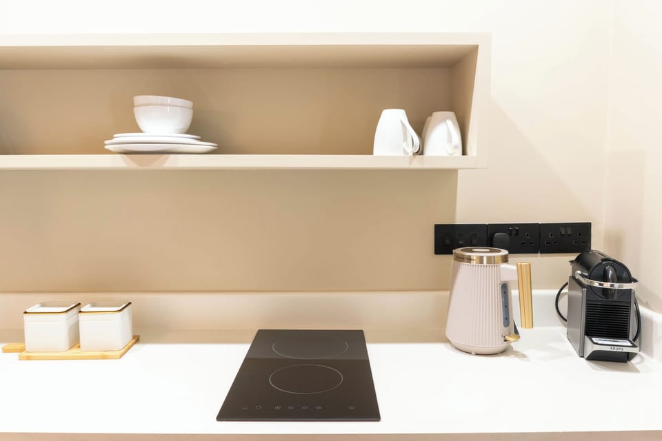 Bright kitchenette with coffee machine, sink & cooking hob