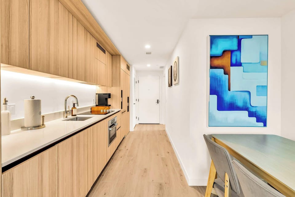 Sleek and modern kitchen with integrated appliances and stylish dining area, perfect for cozy meals.