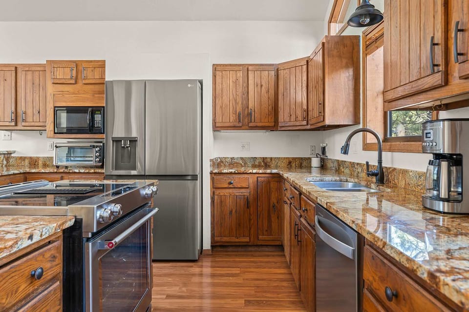 Granite counters wrap this well-equipped kitchen, stainless appliances and a coffee station ready for the whole group. - Kitchen - The Alta - Angel Fire, NM