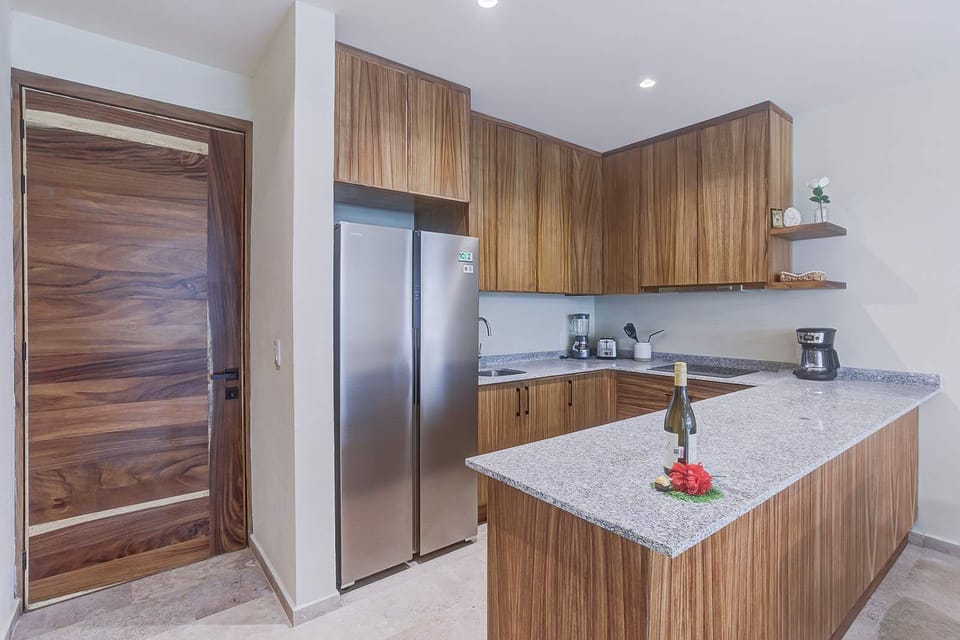 Modern kitchen w/ wood cabinetry, sleek counters & stainless appliances
