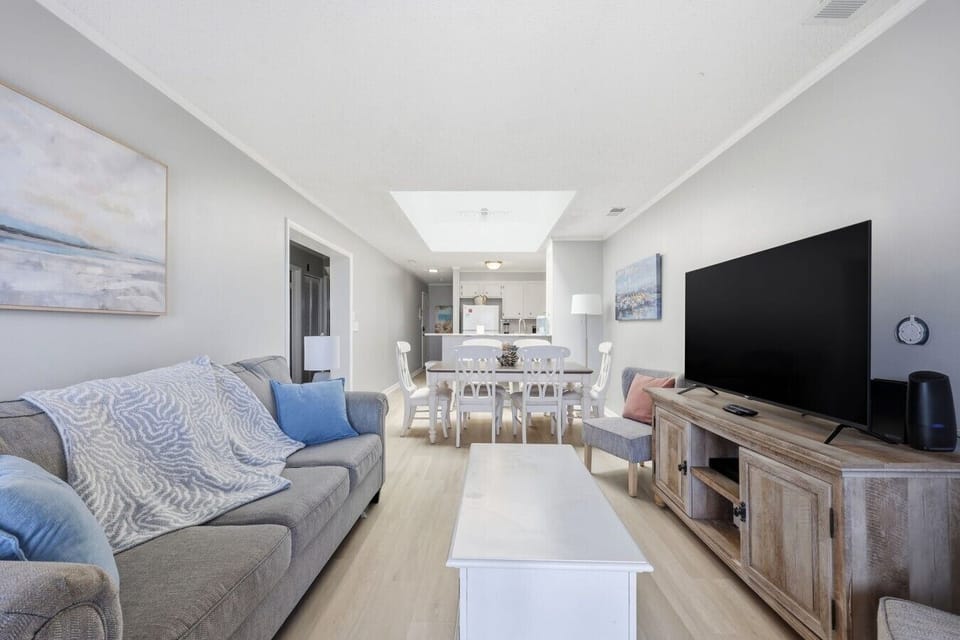 Enjoy the open-concept living area with a large TV, comfortable seating, and a dining space perfect for gathering