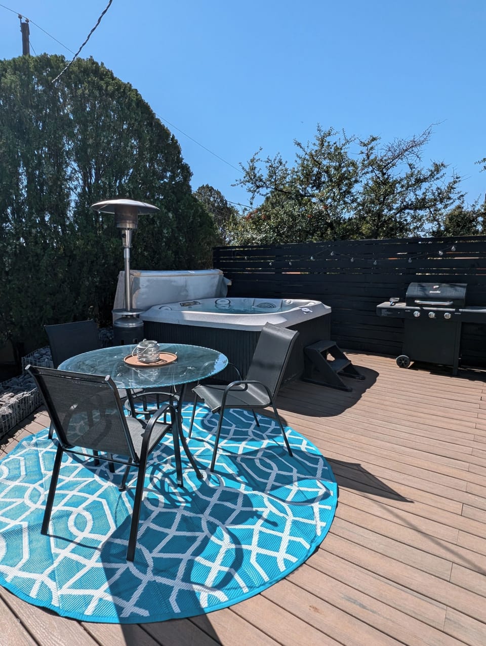 Outdoor dining table, grill and hot tub.