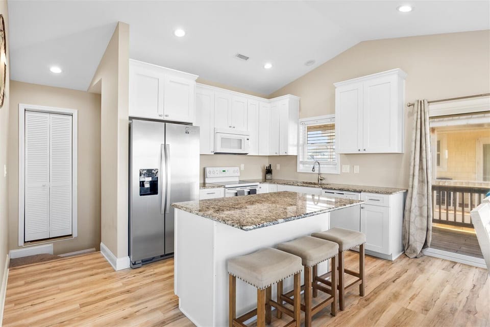 Cook with ease in a spacious kitchen stocked with rental essentials, cookware, utensils, and a coffee maker with complimentary coffee.