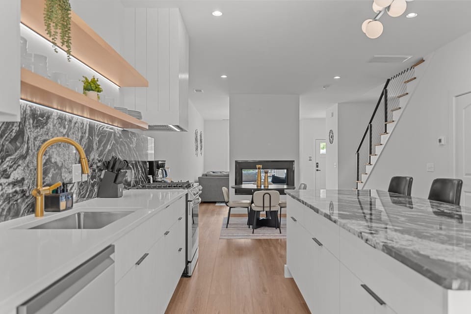 Fully equipped modern kitchen with sleek finishes, stainless steel appliances, and a gas stove.