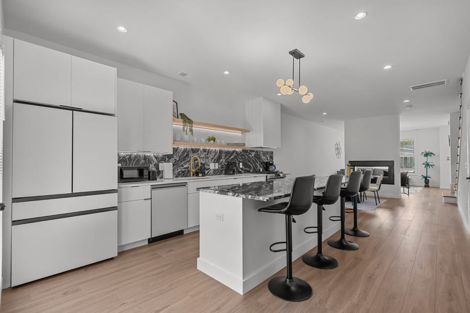 Fully equipped modern kitchen with sleek finishes, stainless steel appliances, and a gas stove.