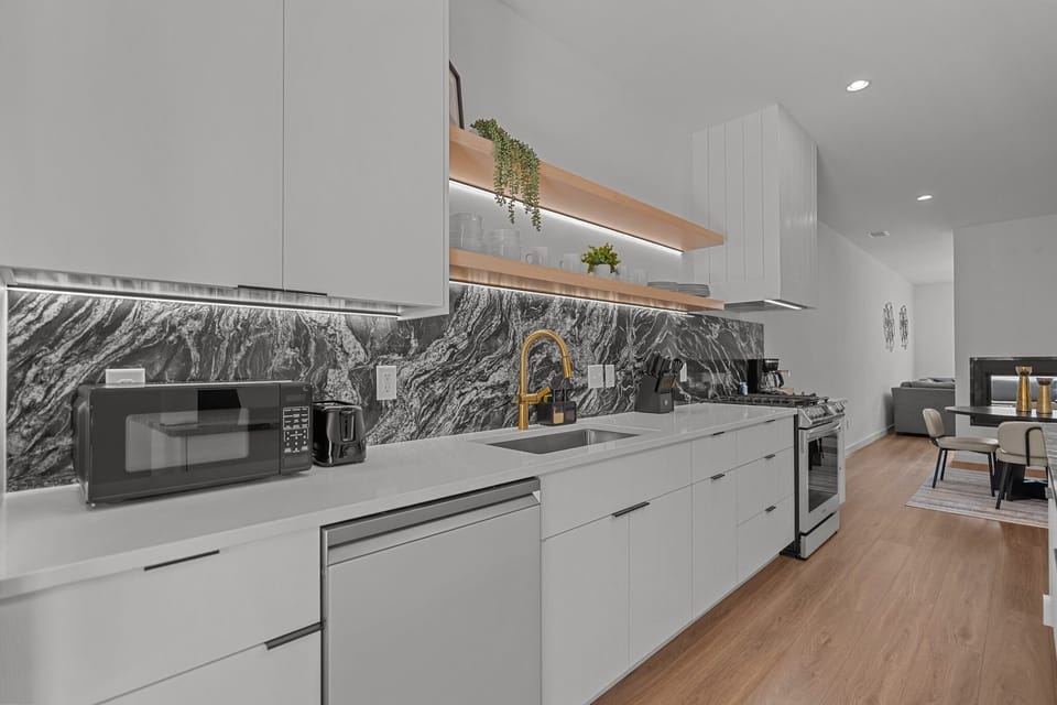 Fully equipped modern kitchen with sleek finishes, stainless steel appliances, and a gas stove.