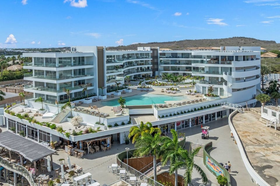 Stunning modern resort with cascading balconies, central pool, and lush landscaping—offering upscale coastal living and relaxation.