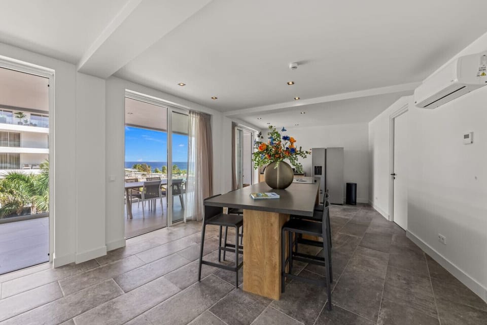 Modern kitchen with island seating and natural light—seamlessly connecting indoor living to a stunning outdoor view.