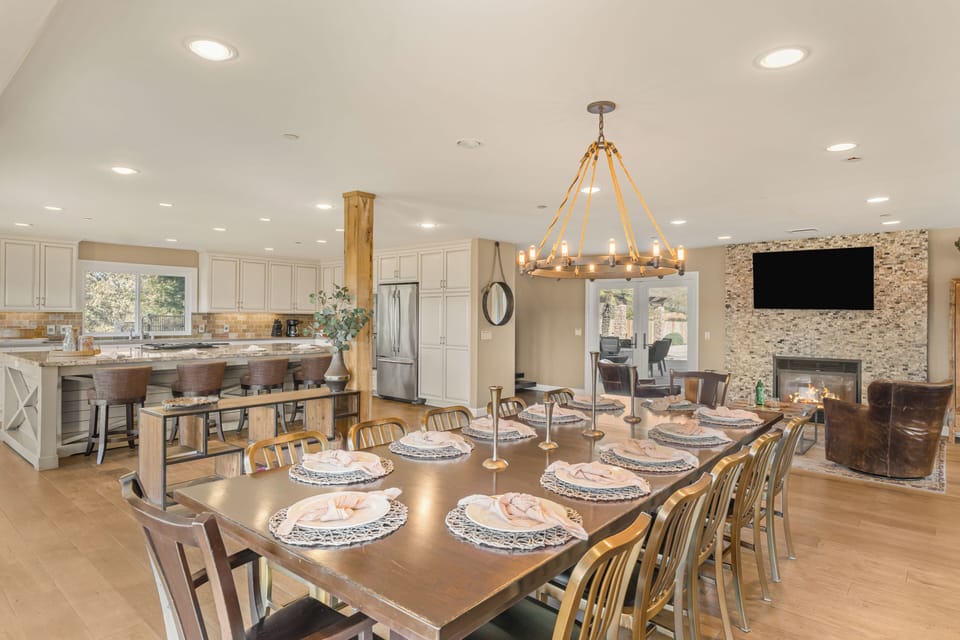 Long formal dining table under a rustic chandelier, perfect for large gatherings.