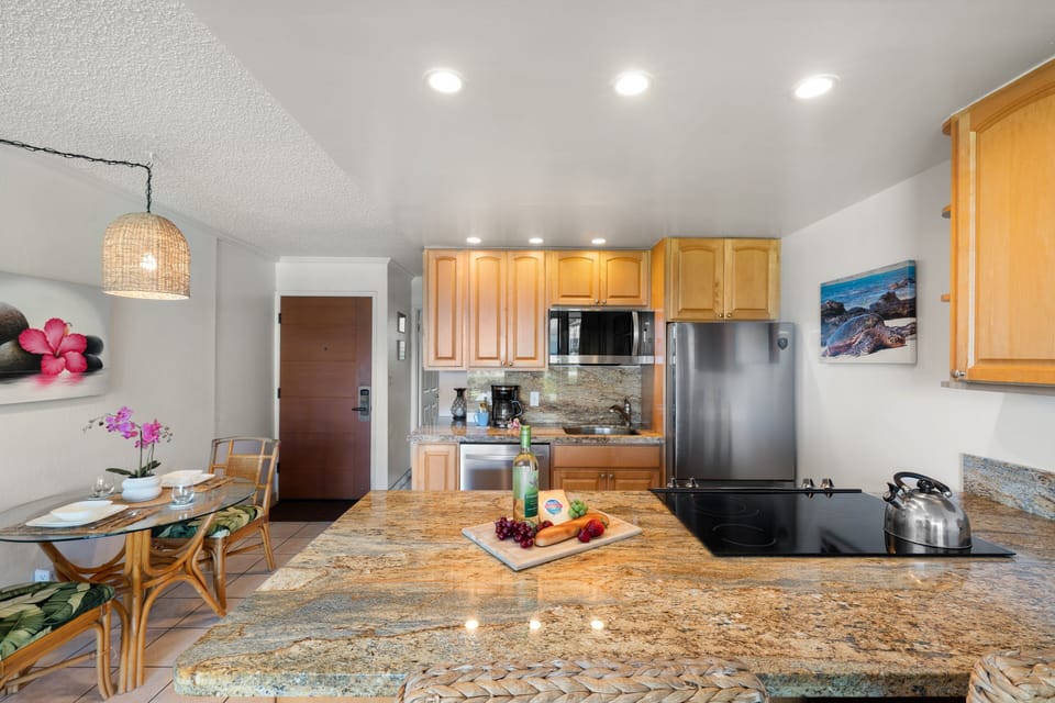 Modern kitchen with granite counters and seating for two guests.
