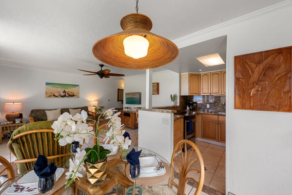 Interior dining area with tropical decor and nearby full kitchen.