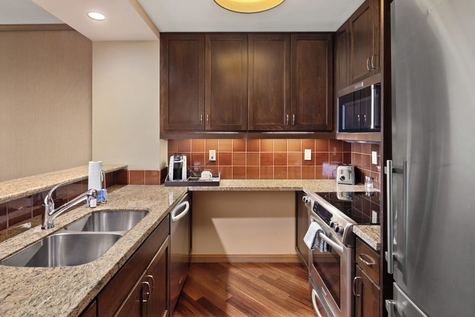 Prepare meals with ease in the stylish kitchen featuring granite countertops, rich wood cabinetry, stainless steel appliances, and thoughtful touches that make cooking both convenient and enjoyable.