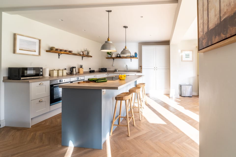 Ground floor: Kitchen island with integrated induction hob and extractor and breakfast bar with three bar stools