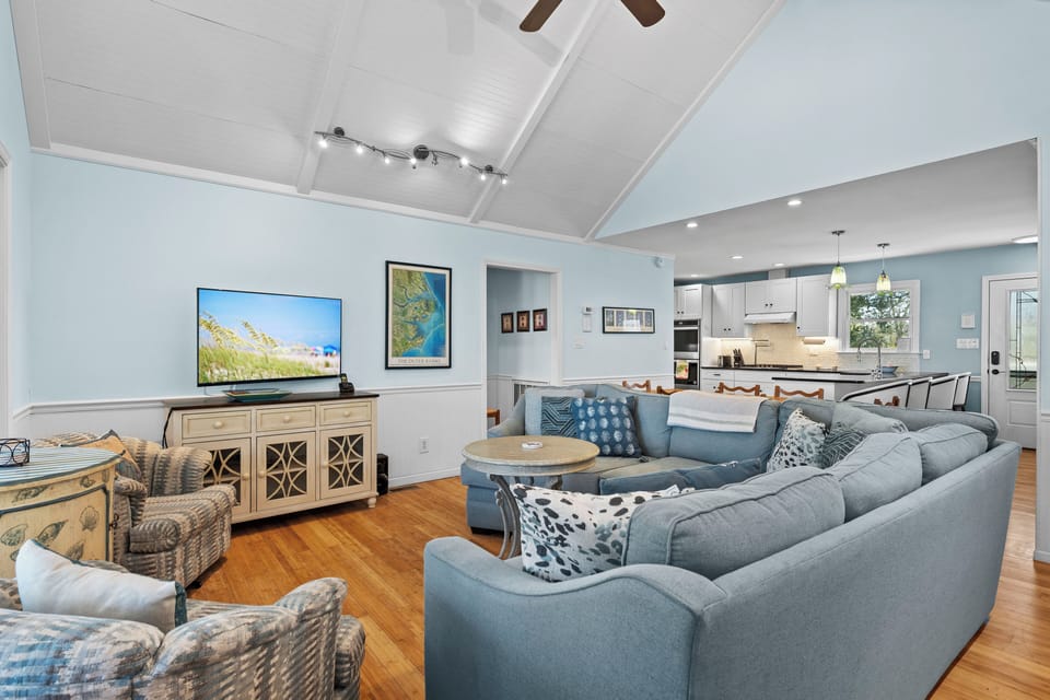 Unwind in your spacious open-concept living area where soft blue tones and comfortable sectional seating create the perfect retreat.