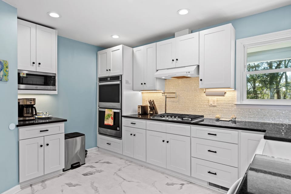 Your spacious kitchen features white cabinetry, granite counters, and modern appliances for creating memorable meals.
