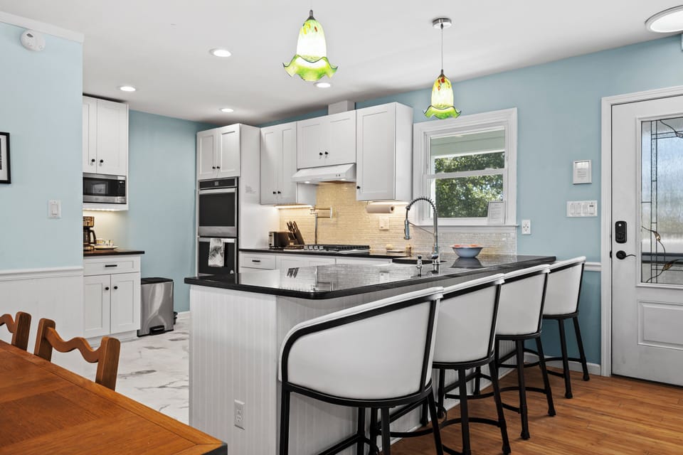 Your bright kitchen features a spacious island for cooking and gathering, with comfortable bar seating and modern appliances.