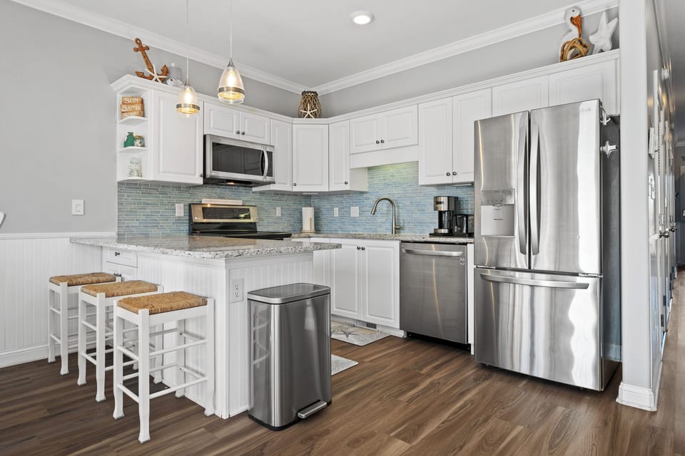 Your fully equipped kitchen features granite counters, stainless appliances, and a breakfast bar where you can savor morning coffee.