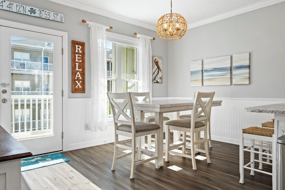 Gather around your bright dining table for memorable meals with coastal charm and golden light streaming through.