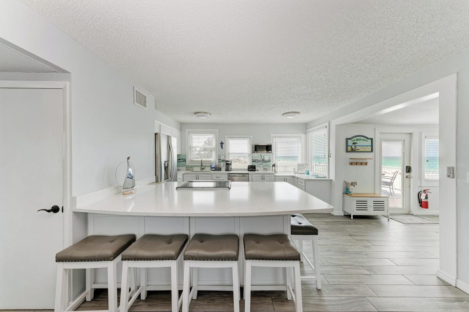 Your spacious gourmet kitchen features gleaming white countertops, modern appliances, and a breakfast bar where you can sip morning coffee while planning your day.