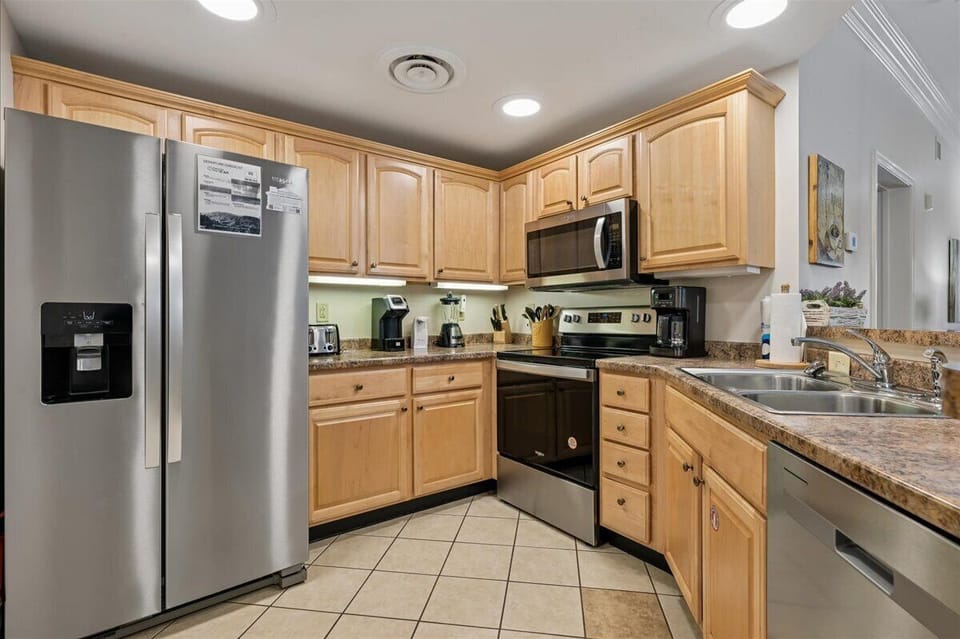 Your fully equipped kitchen features granite counters, stainless appliances, and warm wood cabinets for effortless home cooking.