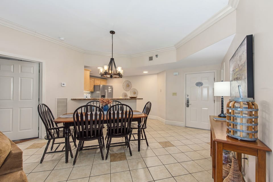 Gather around your elegant dining table for memorable meals in this bright, open space featuring warm wood furnishings and charming coastal décor.