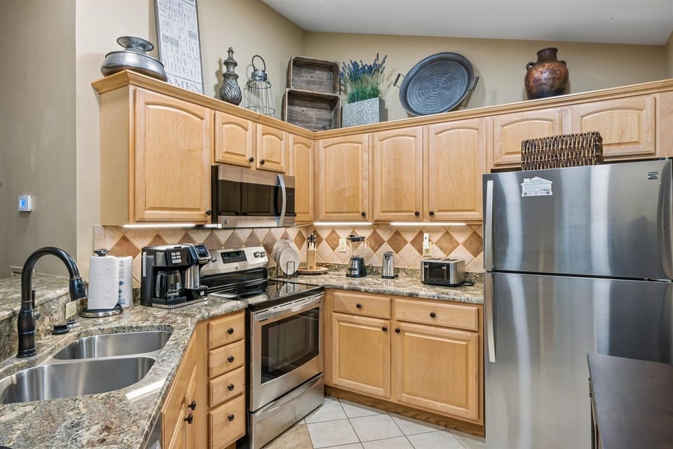 Your fully equipped kitchen awaits with granite counters, stainless steel appliances, and charming decor—perfect for preparing memorable meals together.