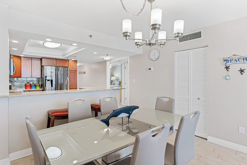 Step into your bright dining space, where a modern chandelier casts a warm glow over meals shared with loved ones. The open layout flows seamlessly into the fully-equipped kitchen, making it easy to gather, cook, and relax together.