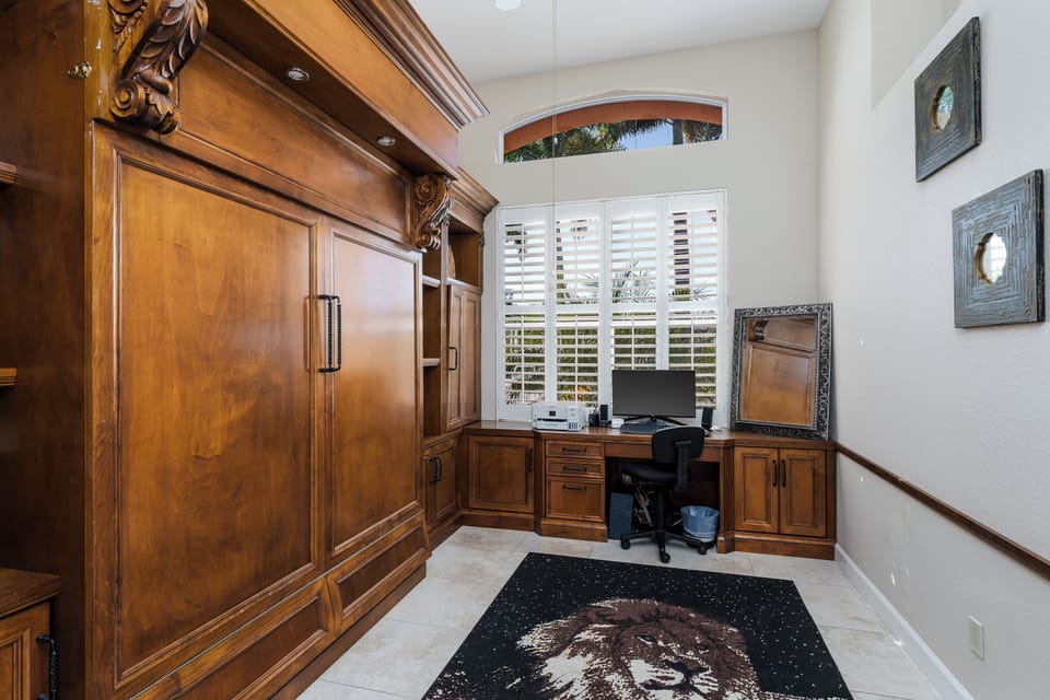 Your dedicated workspace features rich wood built-ins, natural light from plantation shutters, and elegant furnishings for productive remote work sessions.