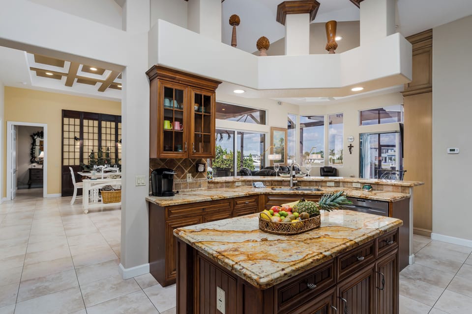 Prepare delicious meals in this stunning gourmet kitchen featuring rich wood cabinetry, granite countertops, and a spacious island perfect for your culinary adventures.
