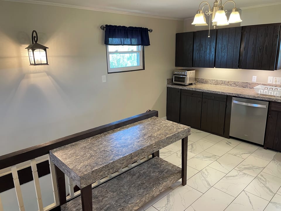 Well appointed kitchen includes Cuisinart toaster oven, dishwasher, and island.
