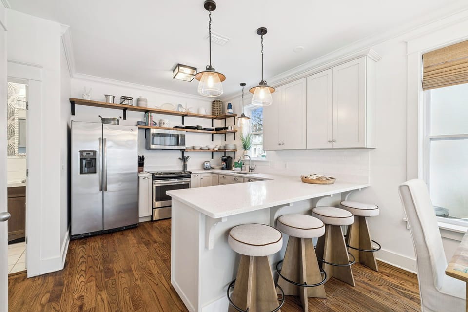 Your bright, modern kitchen features sleek white cabinets, quartz countertops, and a cozy breakfast bar where you can sip coffee while planning your day.