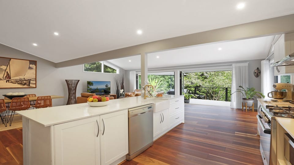 Arcadia Cottage | Kitchen with breakfast bar | Back doors open onto beautiful uncovered deck with lounges and alfresco dining | Central ducted heating throughout property